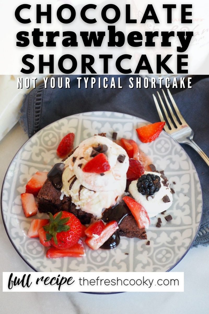 Chocolate Strawberry Shortcake in top down shot with wedge of shortcake, smothered in strawberries, ice cream and whipped cream.