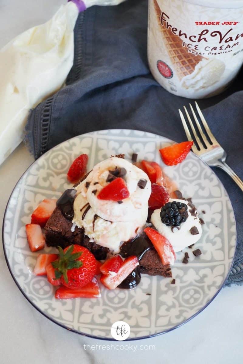 top down shot of chocolate strawberry shortcake with ice cream, strawberries and whipped cream.