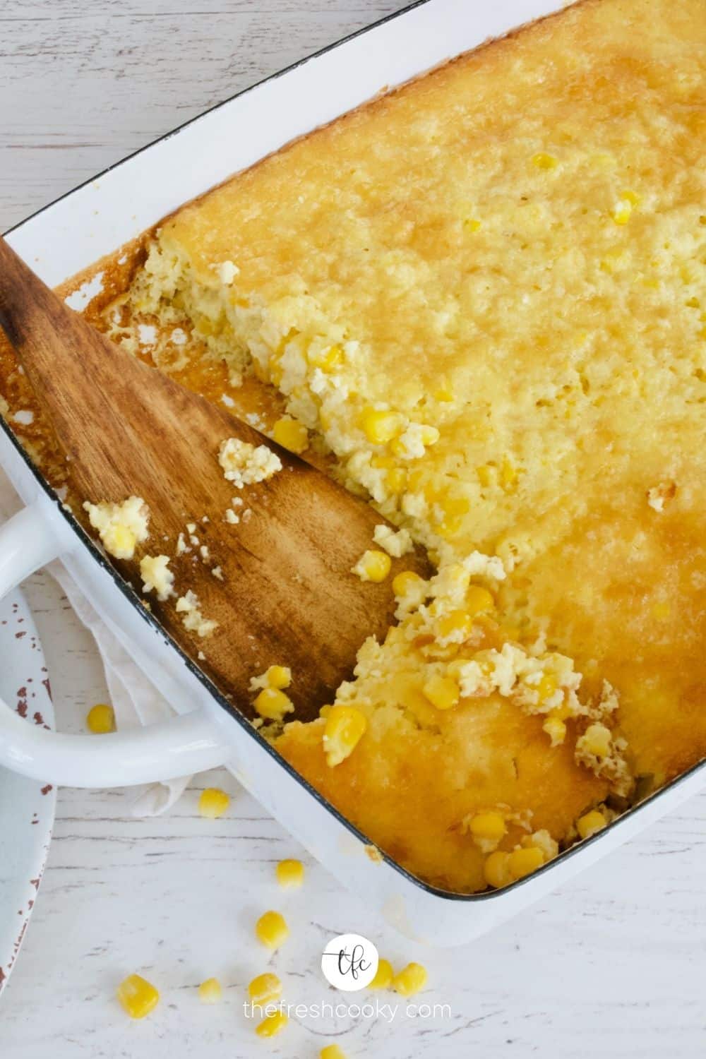 Serving corn pudding with wooden spatula.