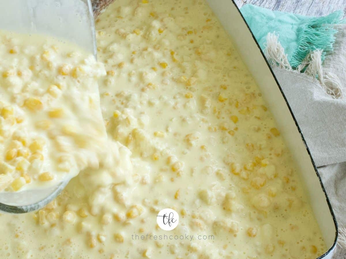 Pouring mixture into casserole dish for corn pudding without jiffy.