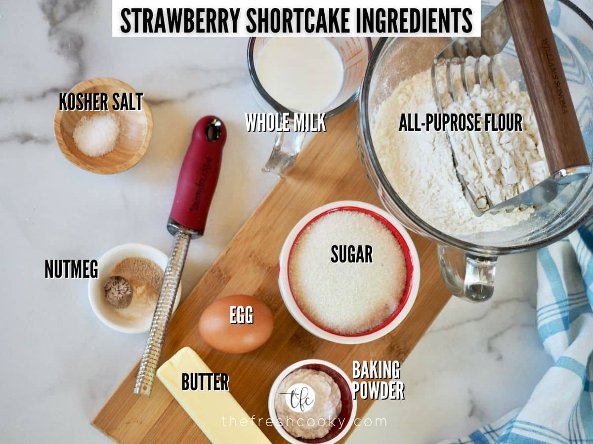 Labeled ingredients for strawberry shortcake cookie recipe L-R salt, milk, flour, sugar, baking powder, egg, nutmeg, butter.