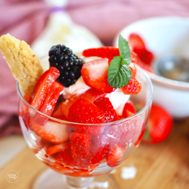 Best Strawberry shortcake cookie recipe with wedge of shortcake in bowl with ice cream, whipped cream and strawberries.