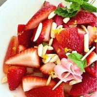Pinterest image for Strawberry Rhubarb Salad on white plate with mint and rhubarb ribbon.