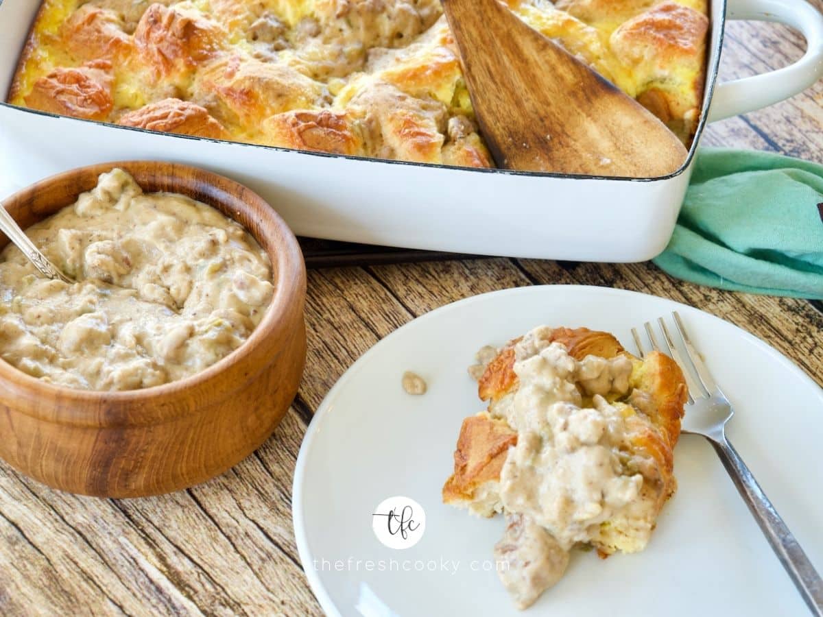 Facebook image for sausage biscuits and gravy egg bake on table with bowl of sausage gravy and slice of egg bake on plate.