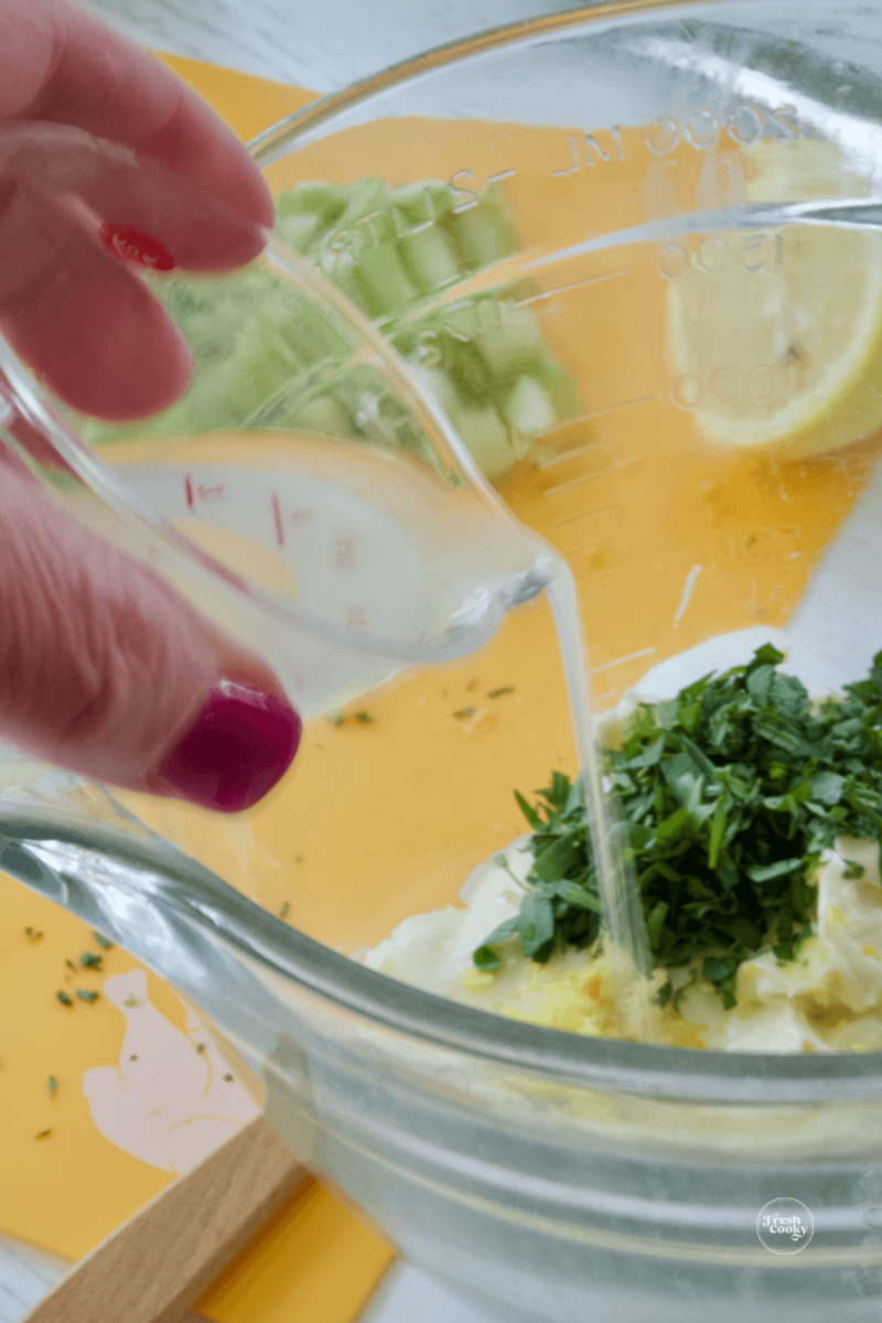 Adding lemon juice to dressing for tarragon chicken salad.