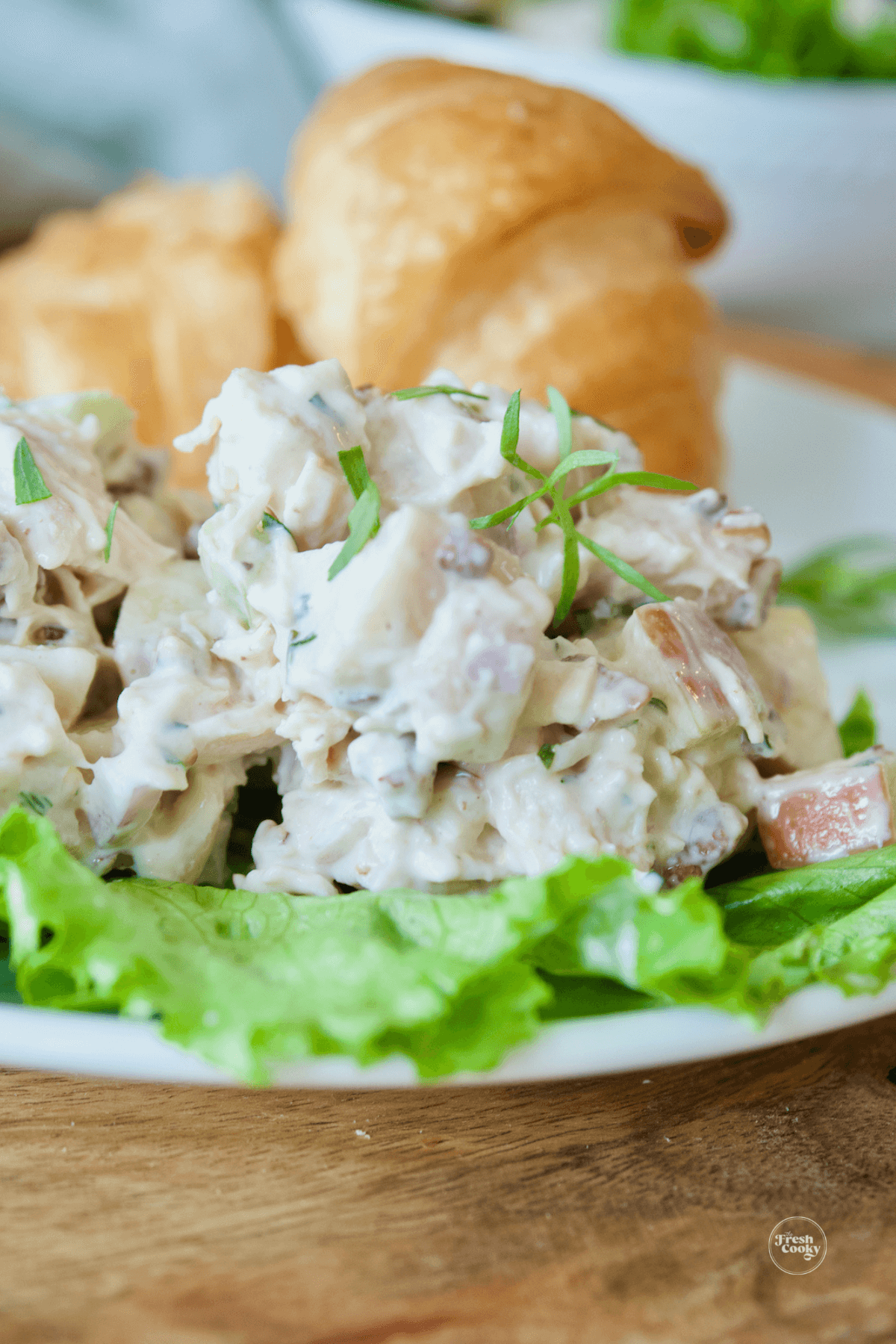 Moist and tender, apple pecan chicken salad on bed of lettuce with croissants.