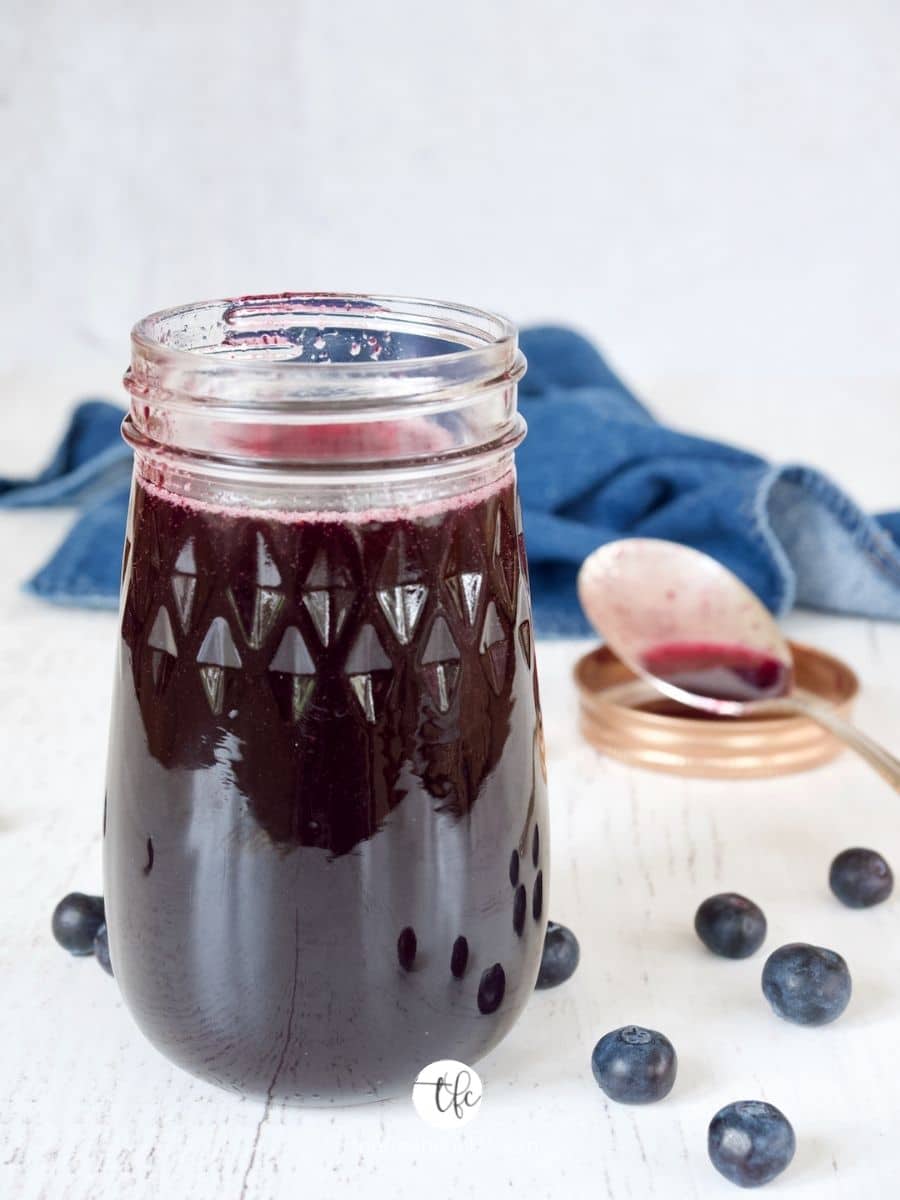Glass jar filled with blueberry simple syrup.