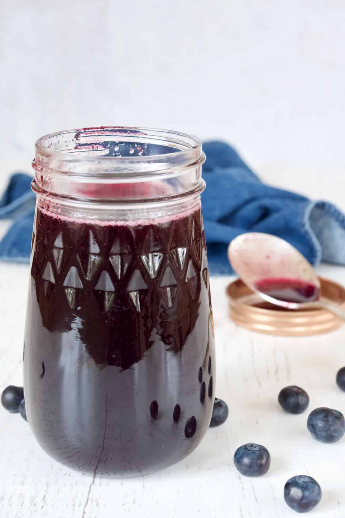 Jar filled with blueberry simple syrup for cocktails and mocktails.