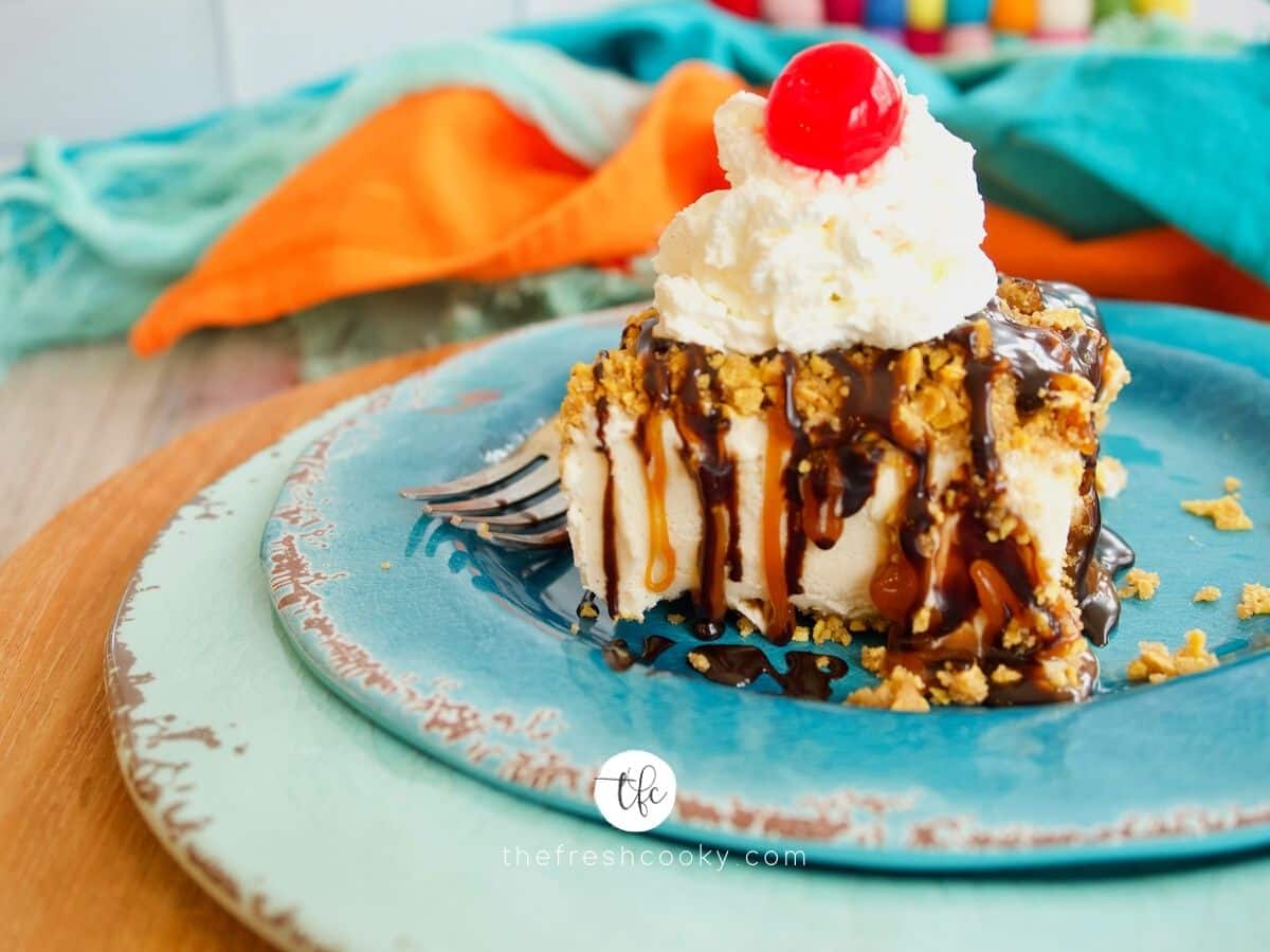 Close up of fried ice cream cake drizzled with chocolate and caramel sauce and topped with whipped cream and a cherry.