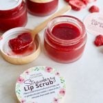 Strawberry DIY Lip Scrub in small jars with printable labels, spoonful of scrub on small wooden spoon.
