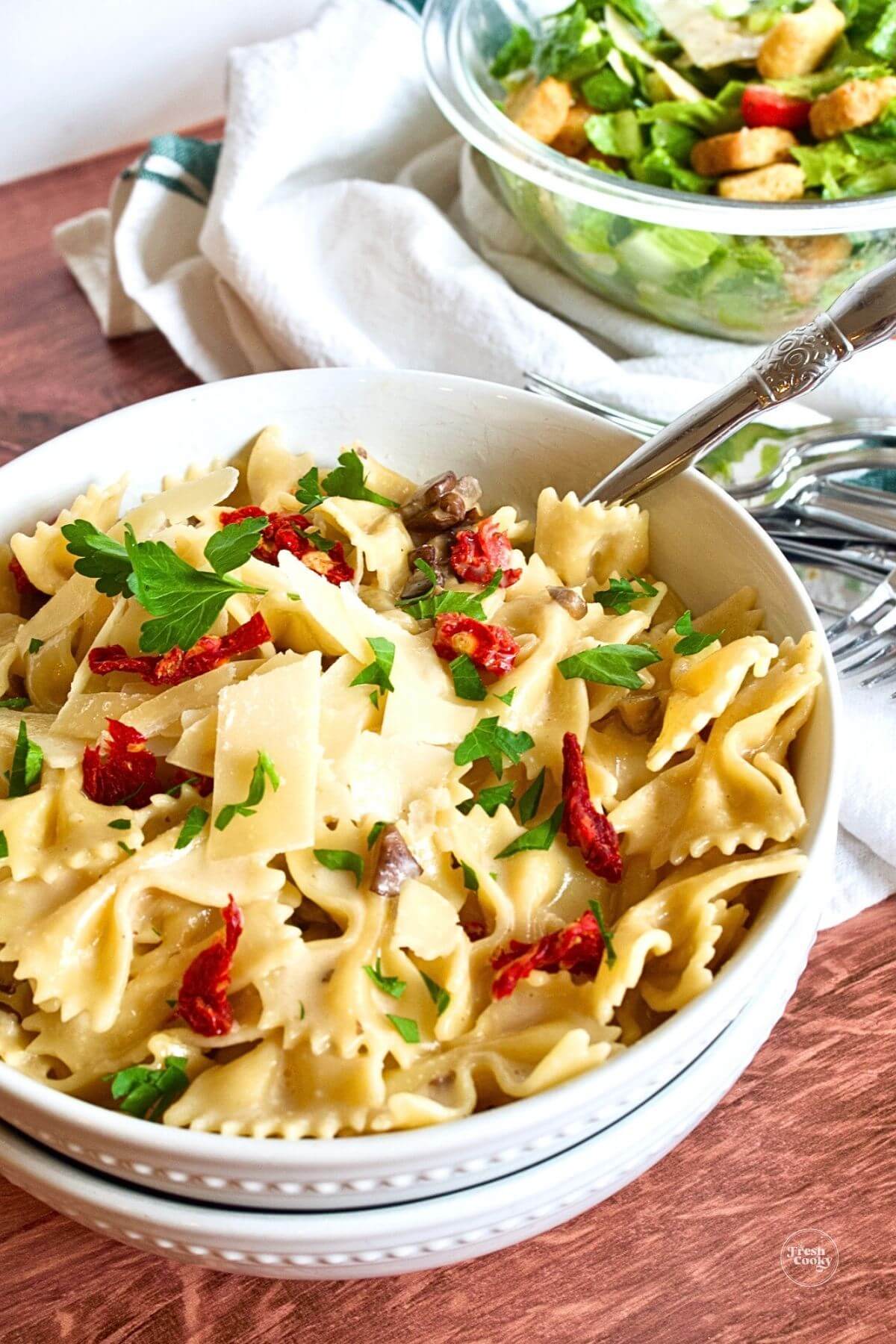 Easy bow tie or farfalle pasta recipe creamy with sun-dried tomatoes, shaved parm and mushrooms.