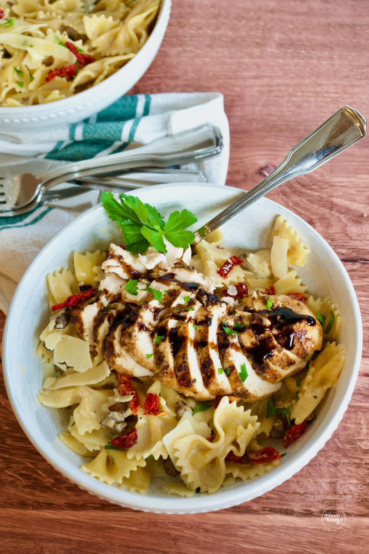 Creamy Bow Tie Pasta recipe with grilled chicken on top.