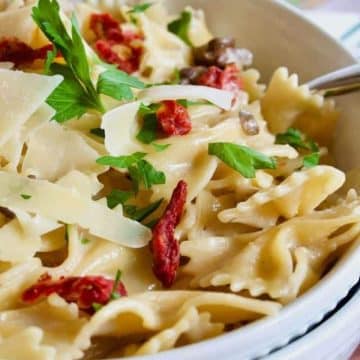easy bow tie pasta recipe in large pasta bowls with spoon.