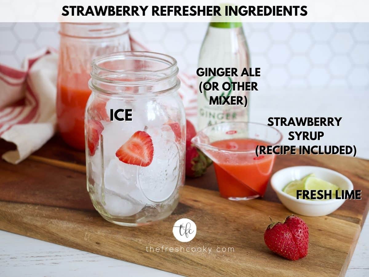 ingredients for strawberry refresher, glass with ice, lime, ginger ale, strawberry syrup.