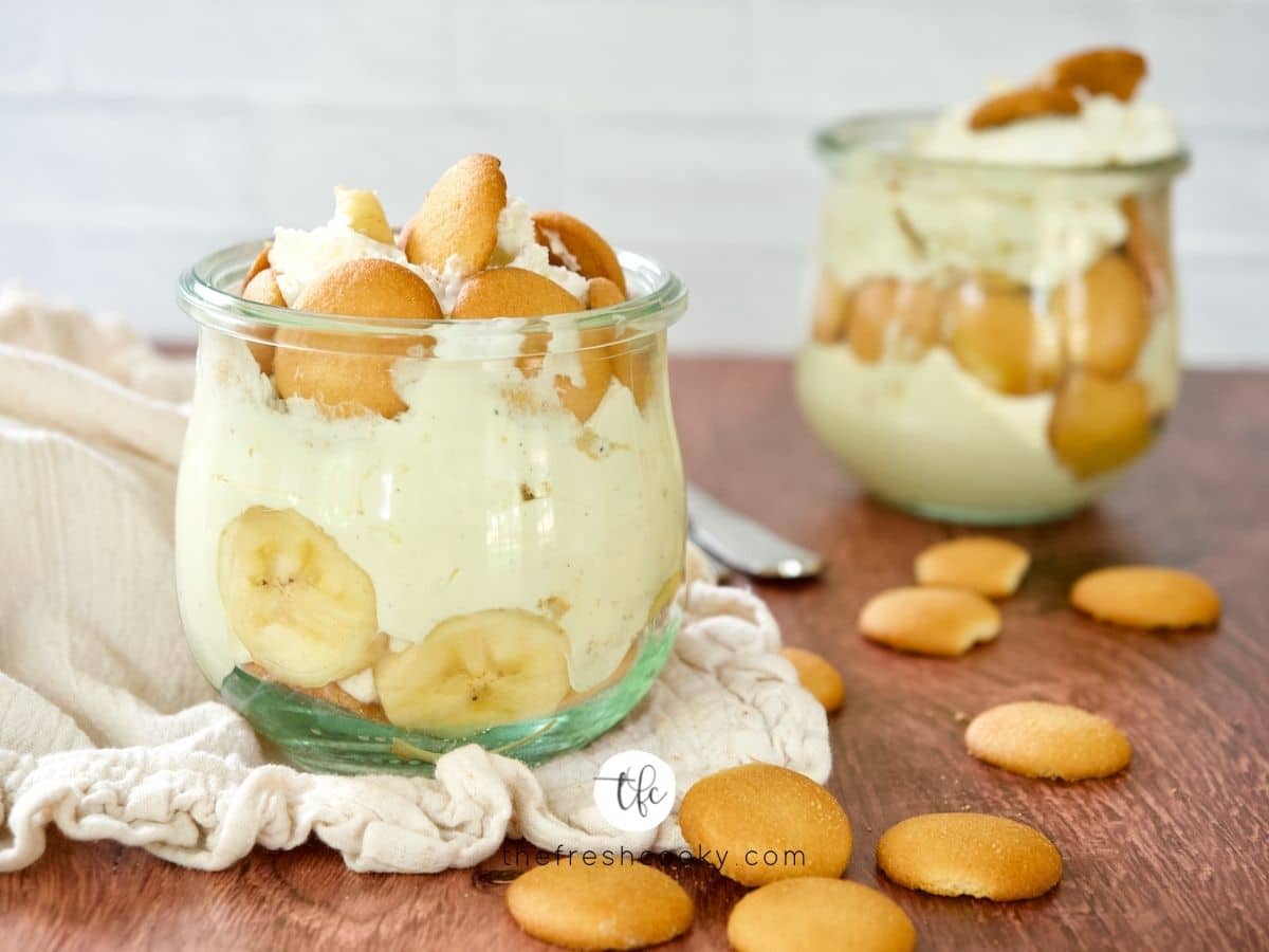 Best Magnolia Banana Pudding in small jars with nilla wafers laying on table.