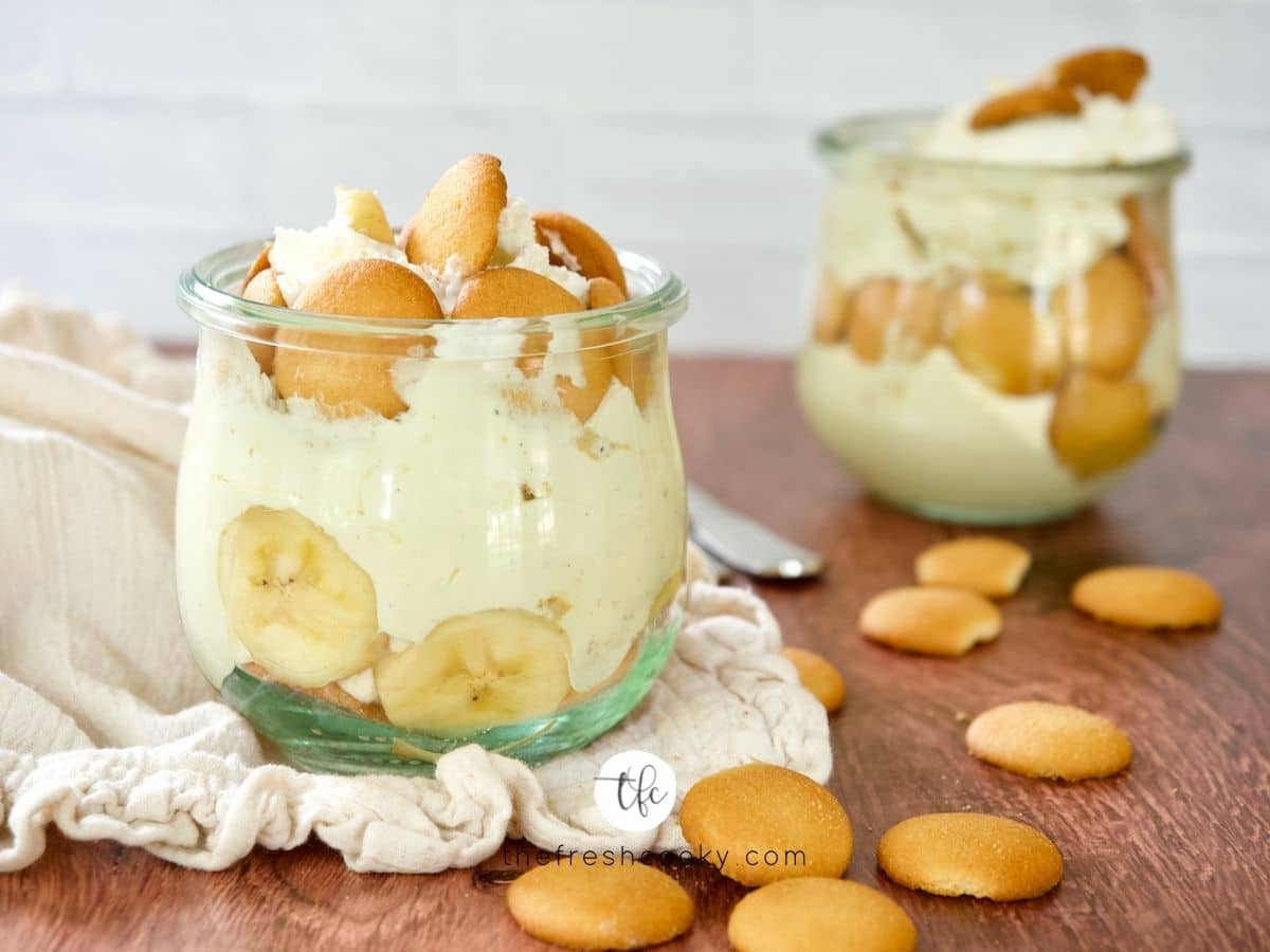 Best Magnolia Banana Pudding in small jars with nilla wafers laying on table.