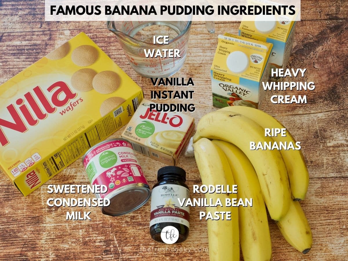 Ingredients on a wooden board for Magnolia Banana Pudding l-r Nilla wafers, ice water, heavy cream, bananas, Rodelle Vanilla Bean paste, sweetened condensed milk and Jell-O Instant Vanilla Pudding mix.