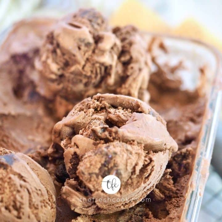 Close up of scooped chocolate brownie ice cream with scoop in background.