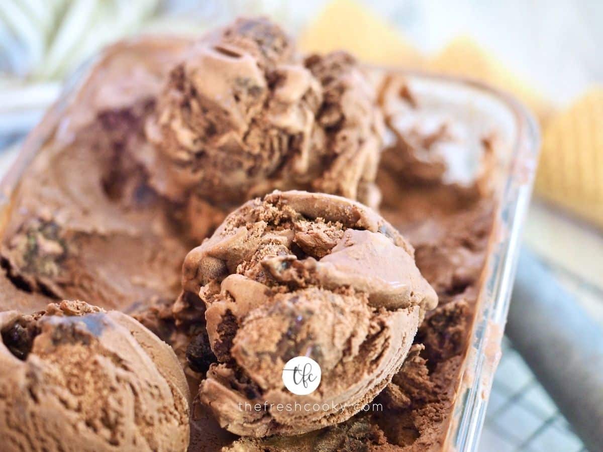 Close up of scooped chocolate brownie ice cream with scoop in background.