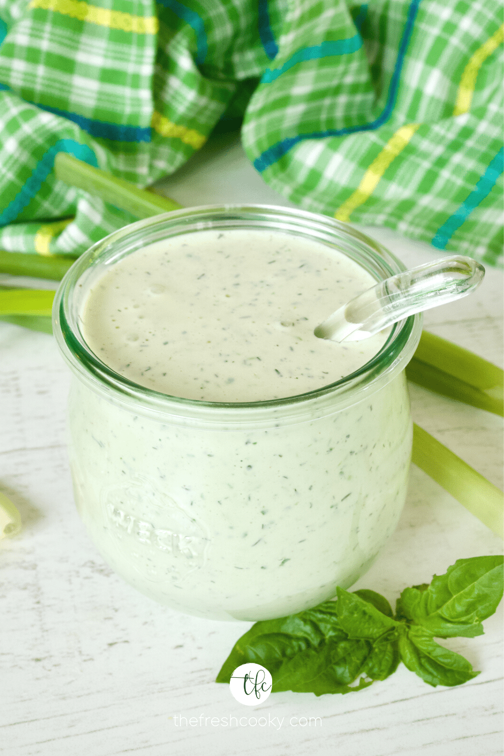 Buttermilk Ranch Dressing in Weck Tulip Shaped jar with glass ladle and fresh basil sitting by jar.