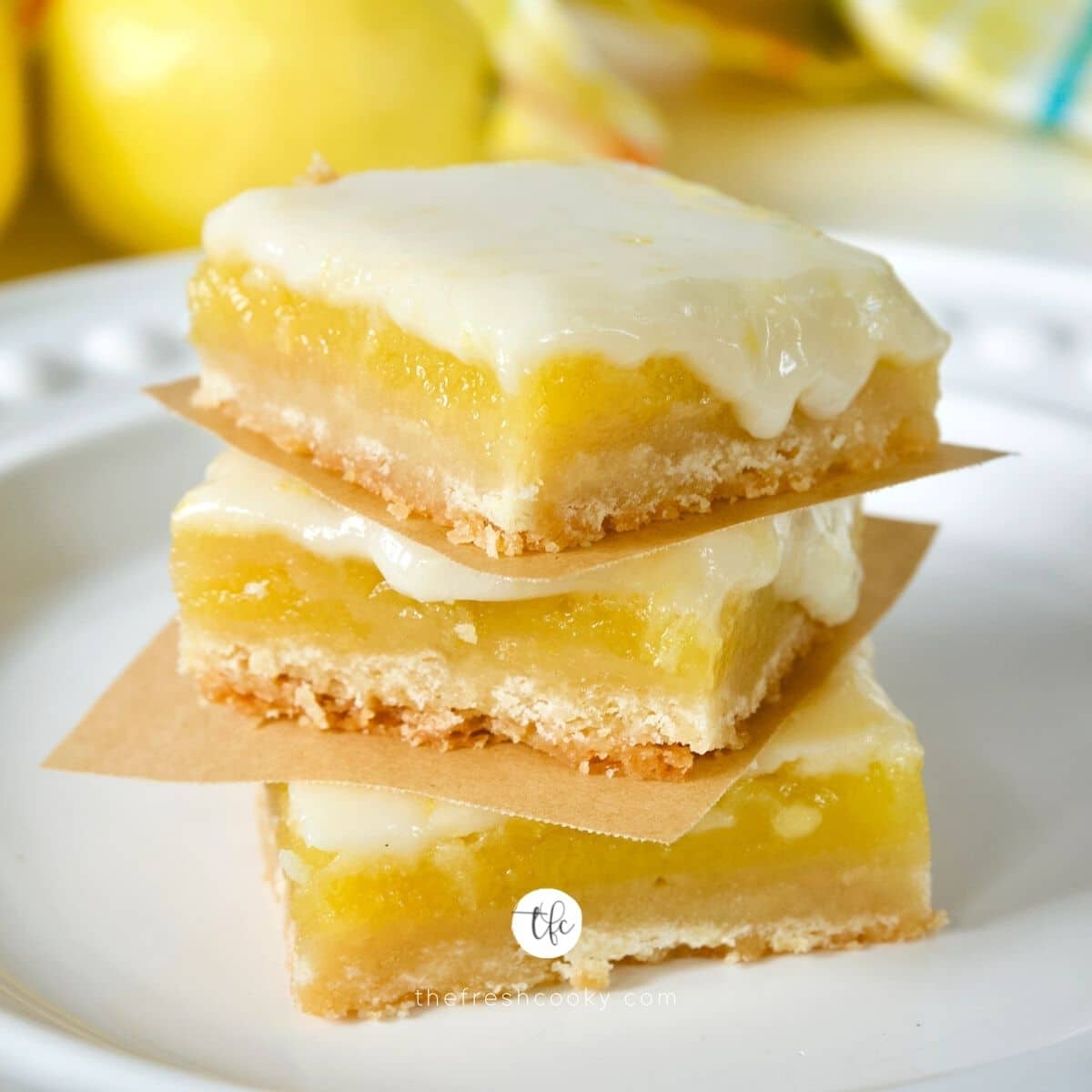 Easy Old Fashioned Lemon Squares square image, with three lemon bars stacked on top of one another.