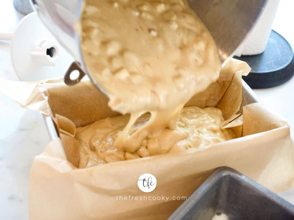 Pouring the rhubarb bread batter into parchment lined loaf pan.