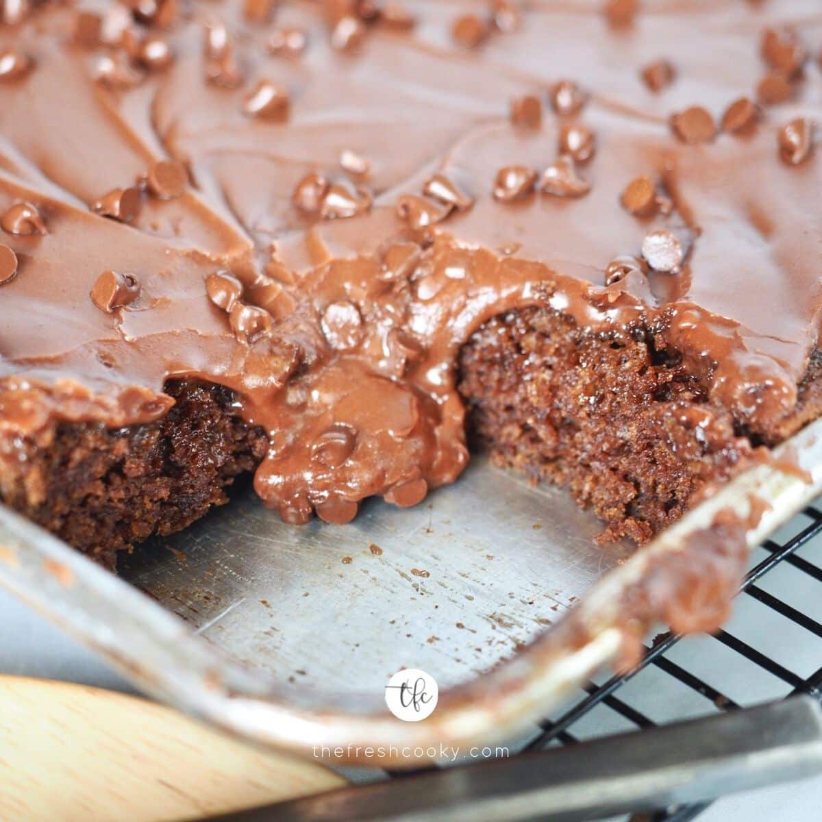Square image of gooey Texas Chocolate Sheet cake with frosting oozing into the space where a slice has been removed.