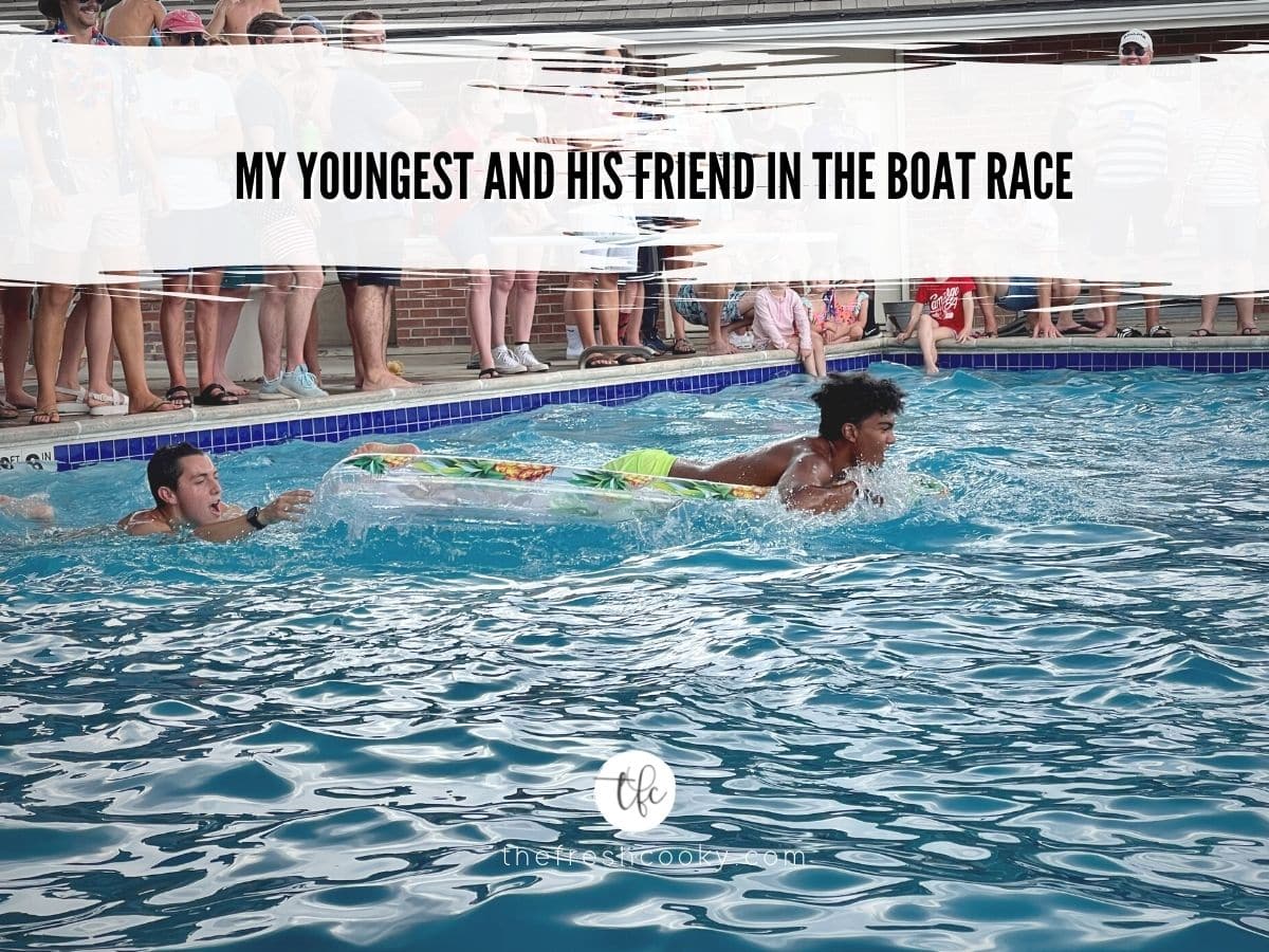 Two boys doing a raft race in the pool.