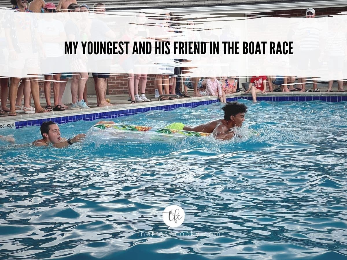 Two boys doing a raft race in the pool. 