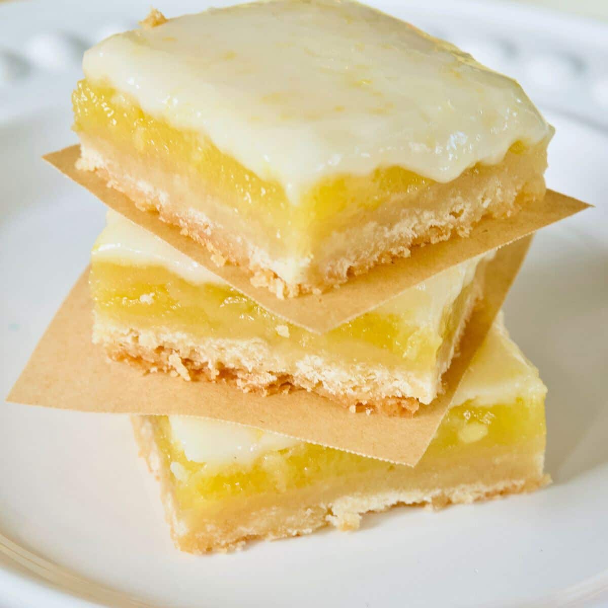 Stacked luscious lemon bars with a gooey lemon glaze.