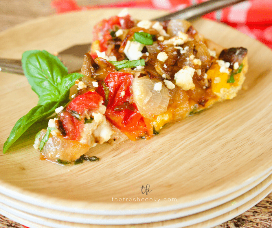 Facebook image with slice of Heirloom tomato pie on a bamboo plate with a rustic fork.