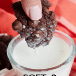 Long pin for triple chocolate cookies with hand holding a piece of a chocolate cookie dipped in a glass of cold milk.