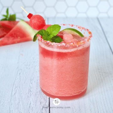 Watermelon Slush in sugar rimmed glass with watermelon balls, mint and lime.