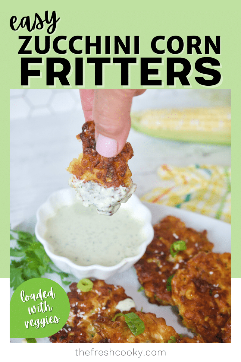 Easy Corn Zucchini Fritters with hand holding fritter piece and dipping into ranch dressing with other fritters on a plate.