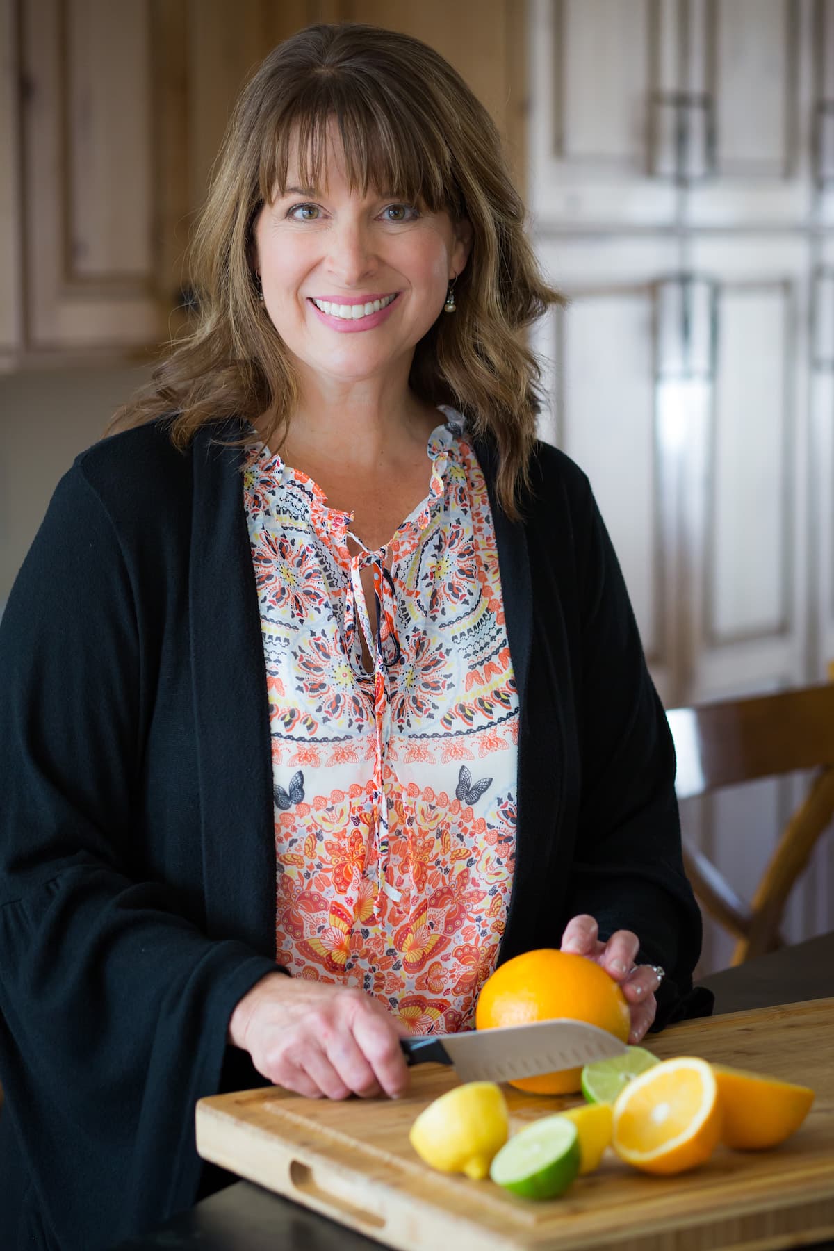 Head shot, Kathleen "The Fresh Cooky" cutting fresh citrus.