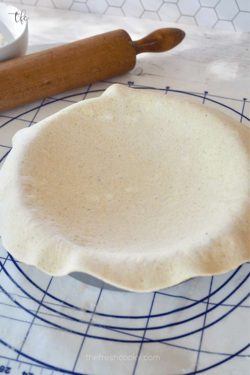 Pizza dough laying over top of 9 inch deep dish pizza pan. 