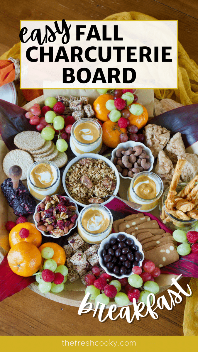 Long pin for easy Fall charcuterie board with beautiful wooden board filled with fall breakfast foods like yogurt, granola, fruit, crackers, nuts, nibbles, cheese and chocolate.