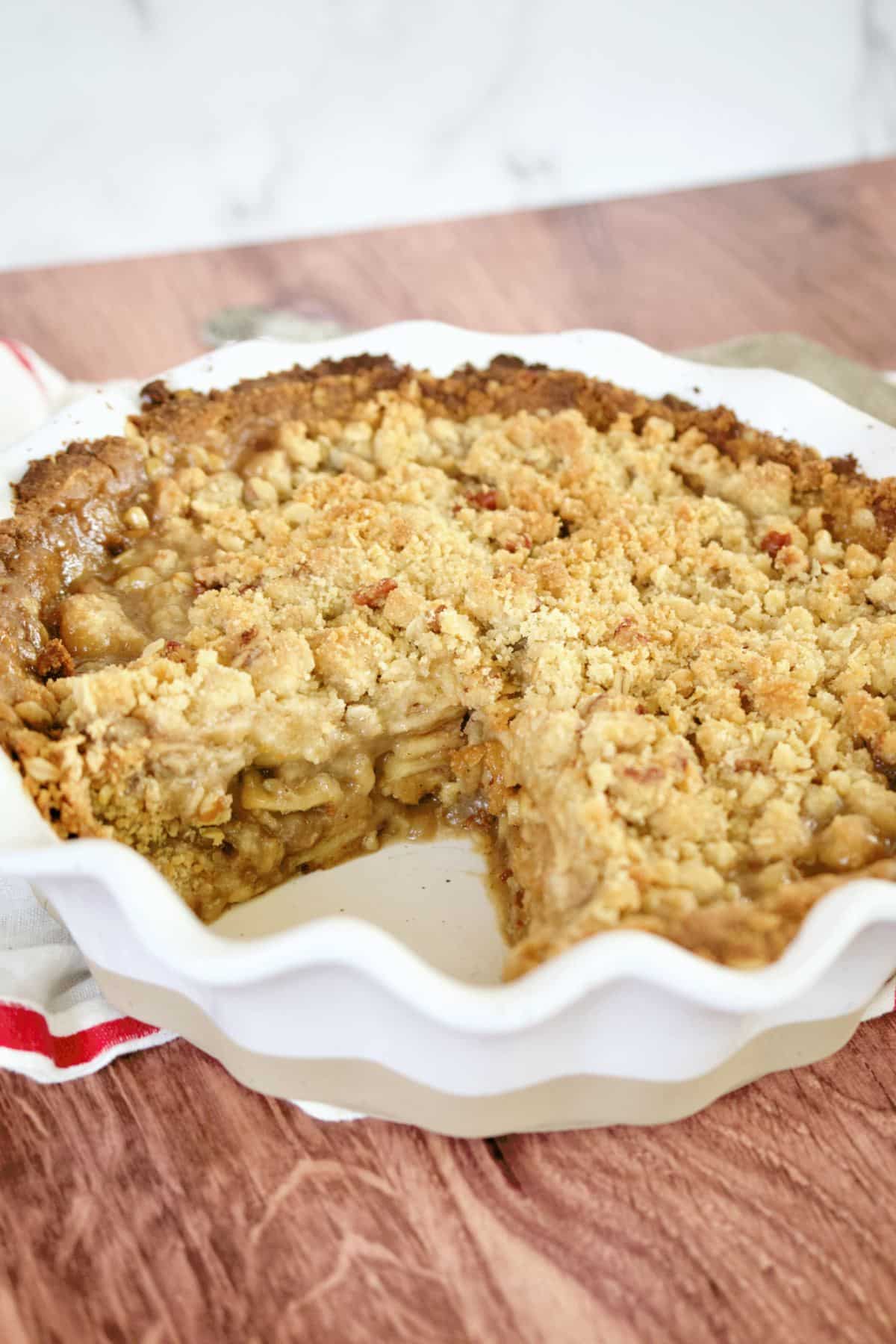 Gluten free apple pie in oven safe dish with slice removed.