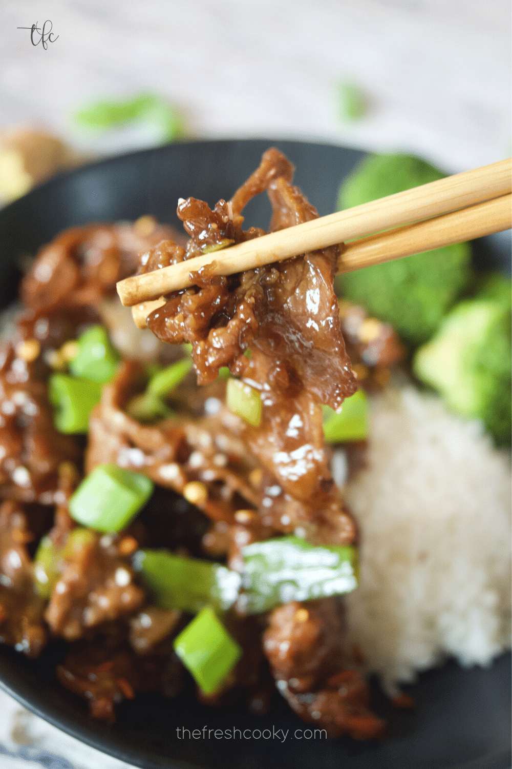 Grabbing a bite of tender Mongolian Beef with chopsticks.