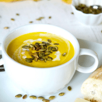 Panera Autumn Squash Soup square image with pepitas in soup and french bread.