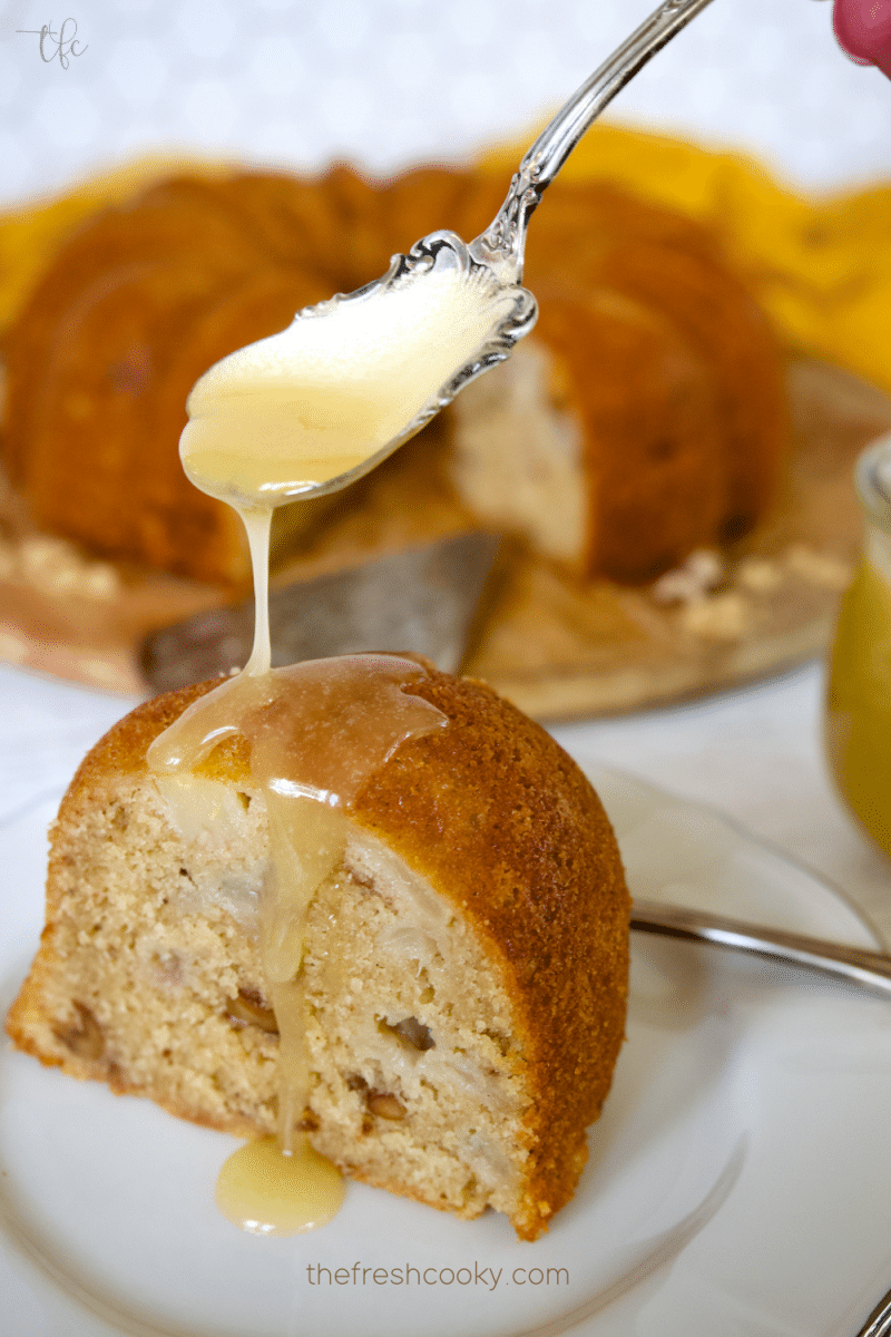 Vanilla sauce being spooned onto pear bundt cake.