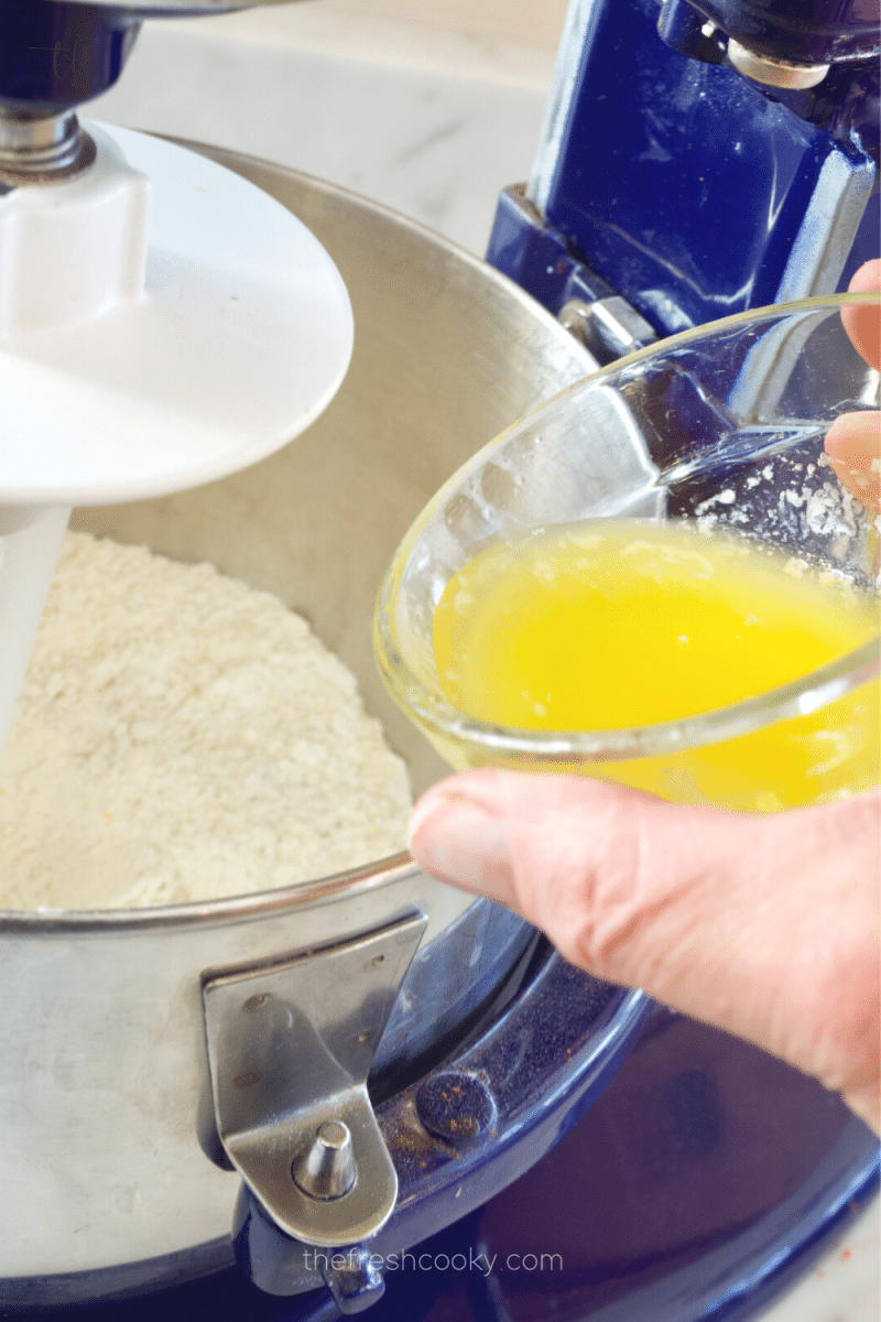 Adding melted butter to butter crust deep dish pizza dough ingredients. 