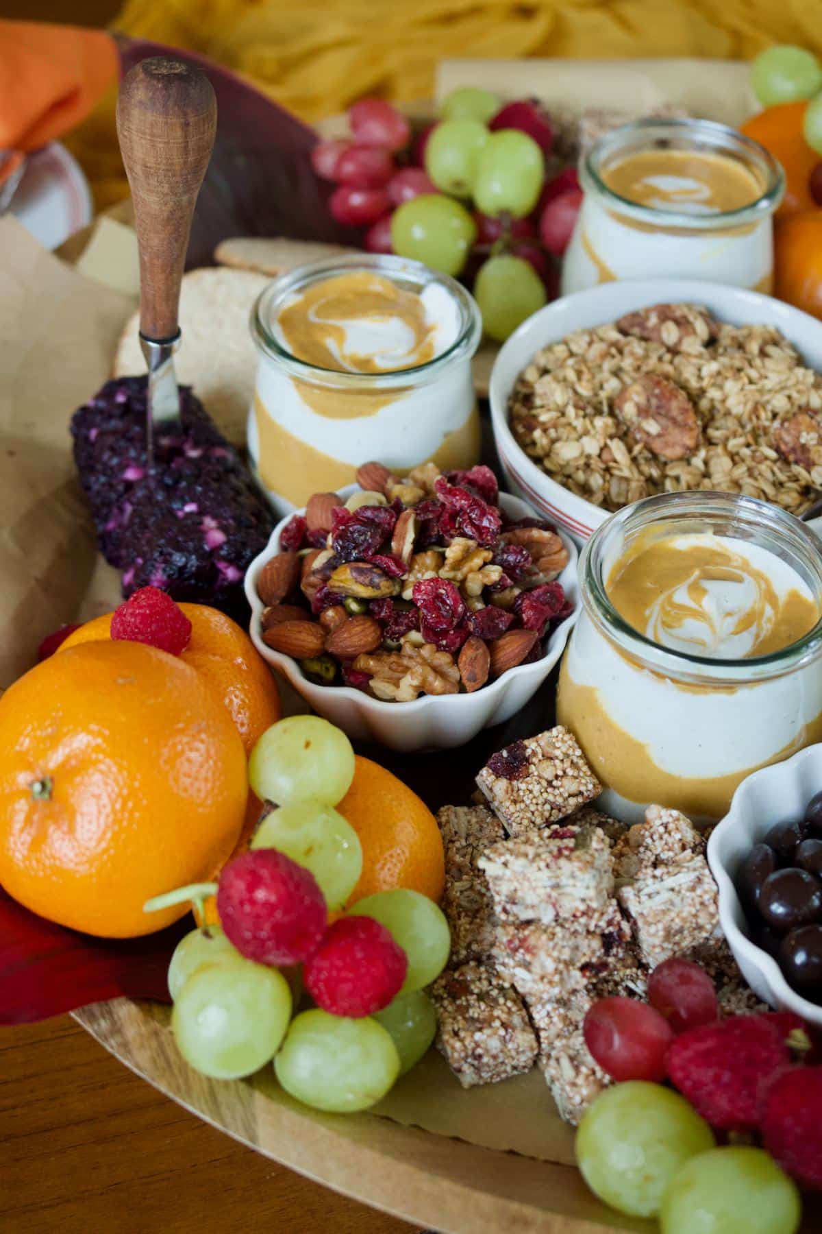 Fall charcuterie board with fresh fruit, yogurt, nuts and granola.
