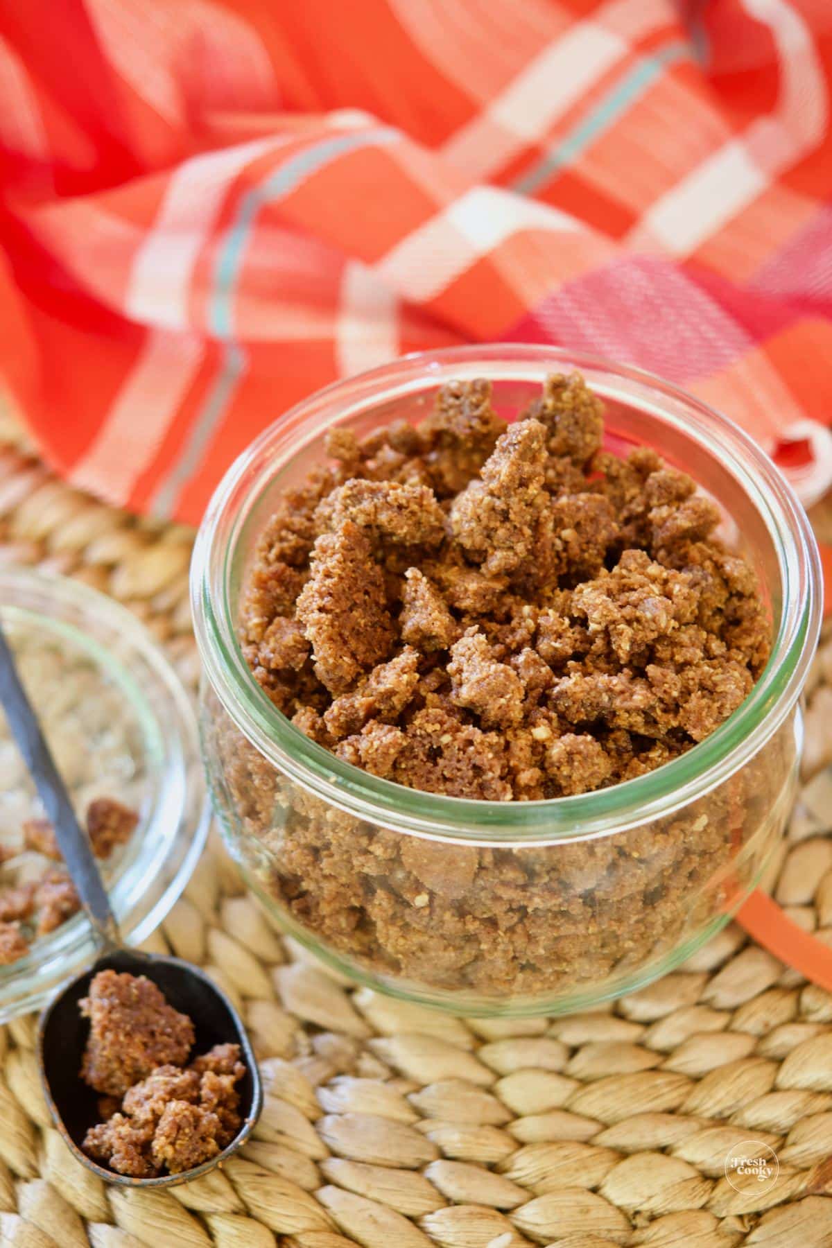 Graham cracker crunch topping in jar with spoonful.