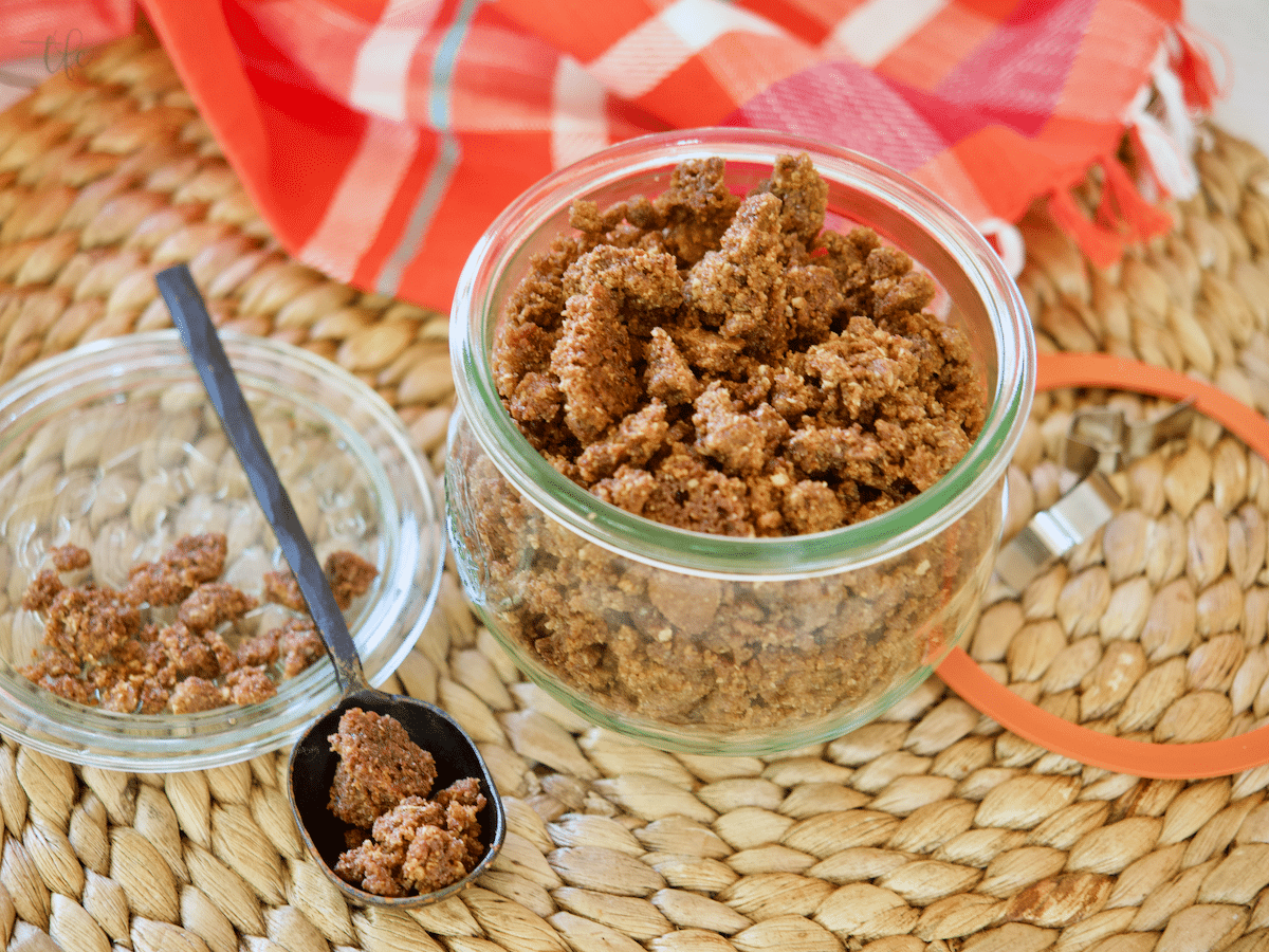 Graham cracker crumble topping in pretty jar with a spoonful to the side.