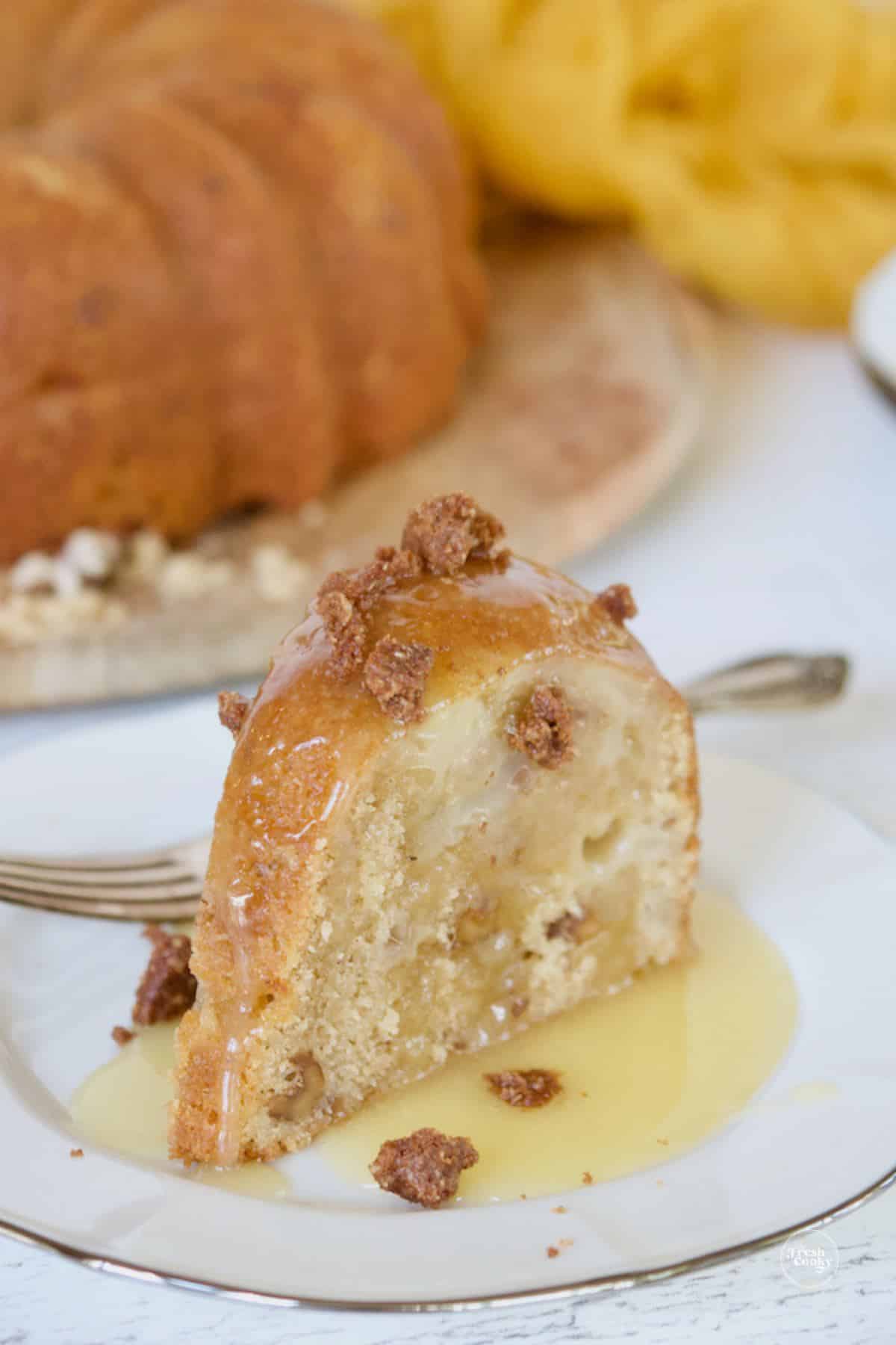 Graham crunch topping on pear bundt cake with vanilla sauce.