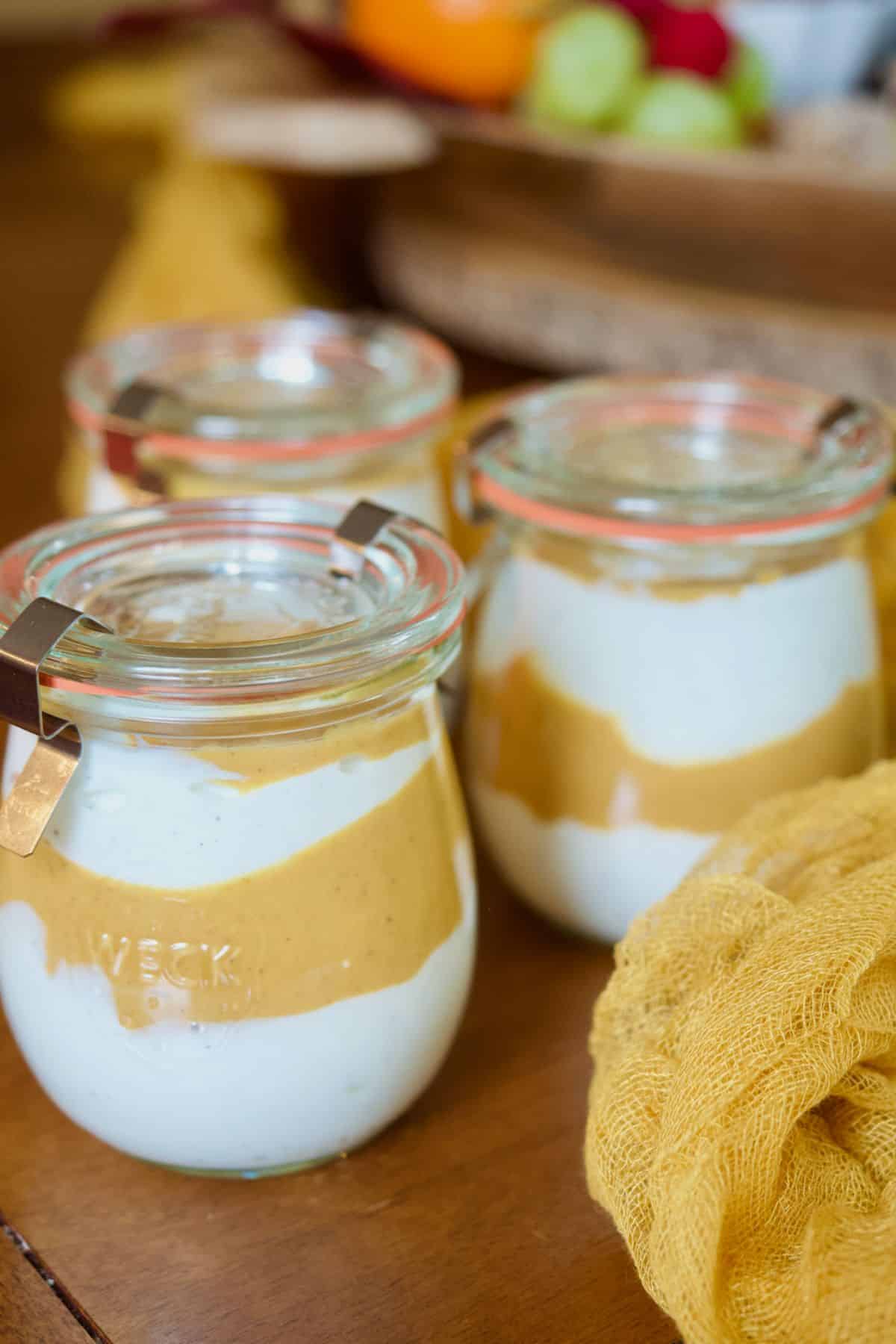 Pumpkin yogurt parfaits in jars, ready to store or serve. 
