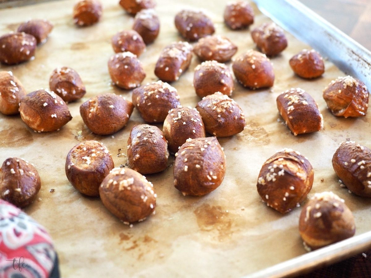 Pretzel Bites baked in oven with image of pretzel bites on parchment lined baking sheet.