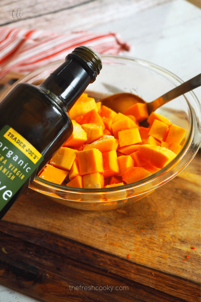 Drizzling butternut squash with olive oil.