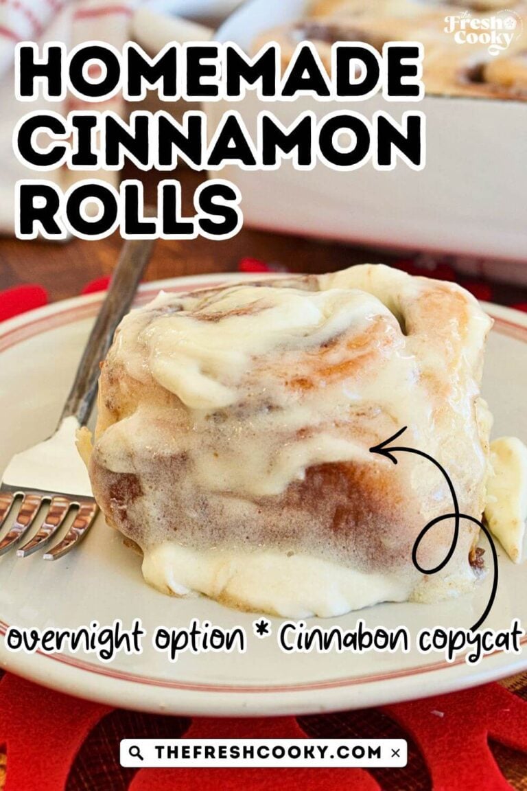 A gooey cinnamon roll with frosting on a white plate with red trim, for pinning.